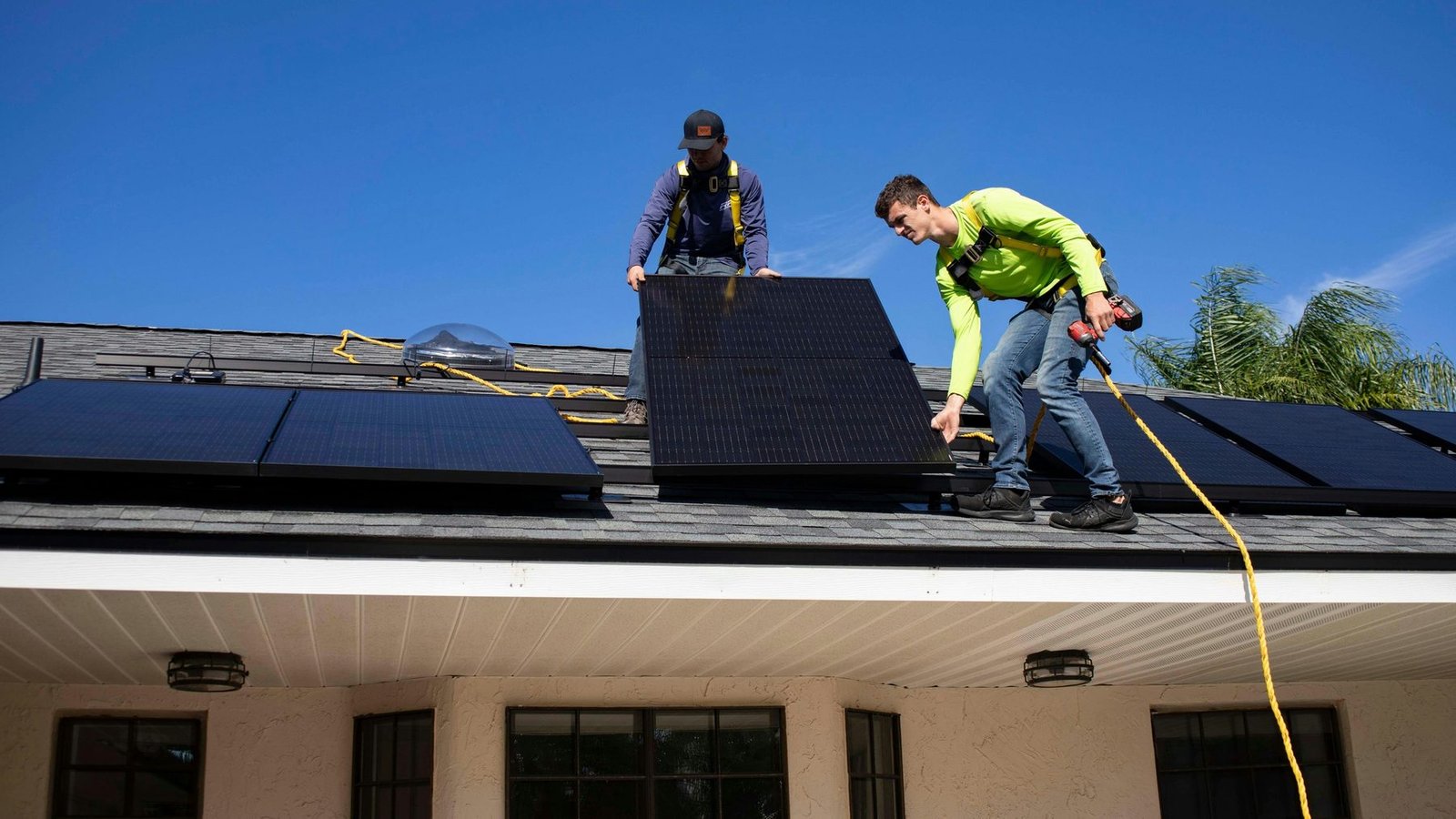 Dos instaladores colocando un módulo fotovoltaico sobre una cubierta